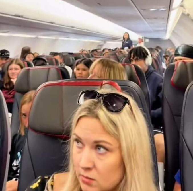 I passeggeri hanno voltato la testa quando è apparsa indicando il retro dell'aereo mentre parlava di un ragazzo che non era reale.