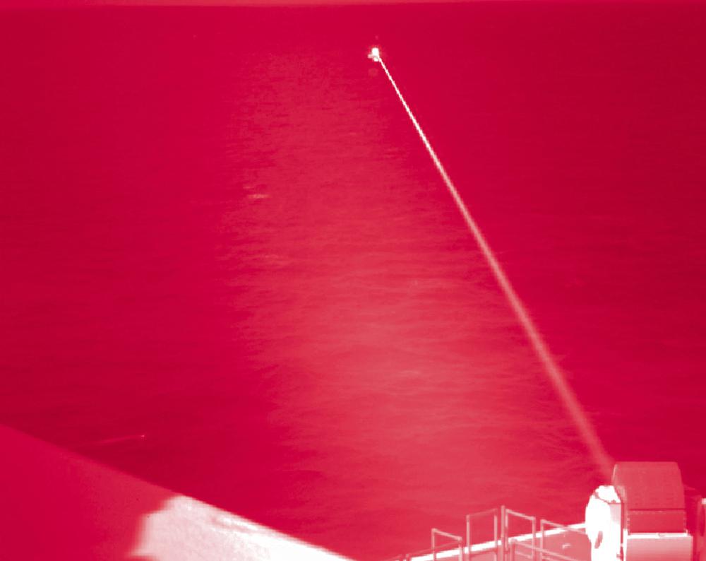 Nesta foto infravermelha da Marinha dos EUA, o USS Portland dispara um sistema de armas a laser contra um alvo flutuante no Golfo de Aden na terça-feira, 14 de dezembro de 2021.