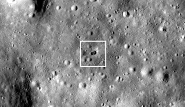 Uma cratera dupla e um pequeno objeto dentro.