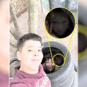 Foto aterrorizante de um menino ao lado do rosto de uma garota fantasma