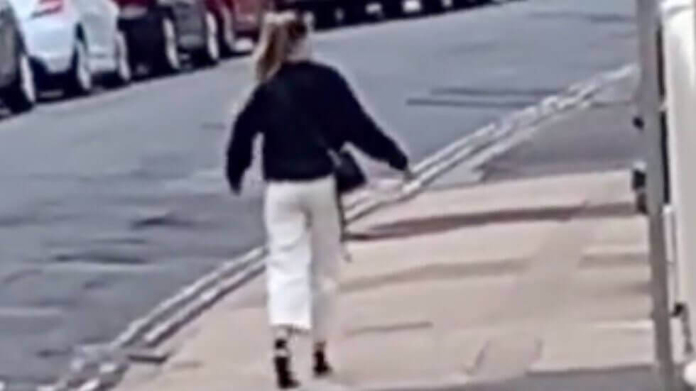 Uma captura de imagem (com zoom) da mulher aparentemente congelada por alguns segundos no meio da rua enquanto caminhava