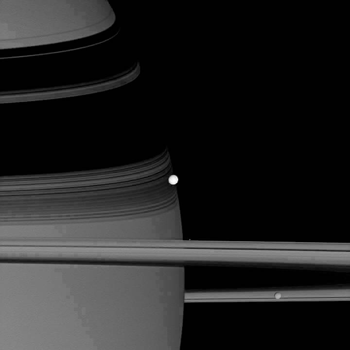 A espaçonave Cassini capturou esta imagem do reflexivo Encélado, visível no centro, enquanto orbita Saturno. Também podem ser vistas na imagem de 2007 mais duas luas: Pandora, um ponto brilhante flutuando perto dos anéis, e Mimas, no canto inferior direito.